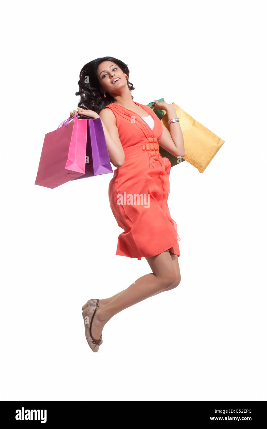 Portrait of a woman jumping with shopping bags Stock Photo