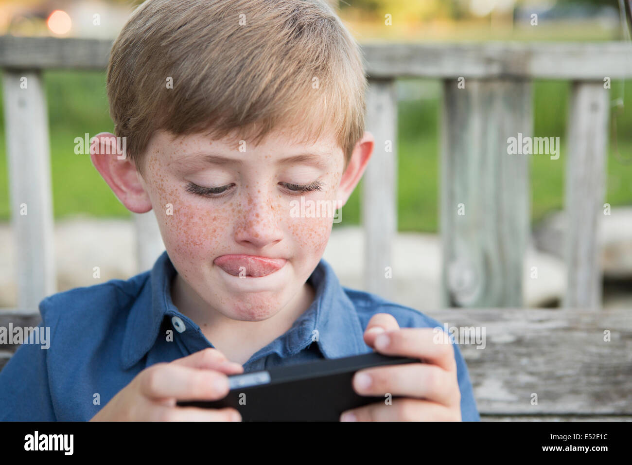 Boy sticking out his tongue which is very red hires stock photography