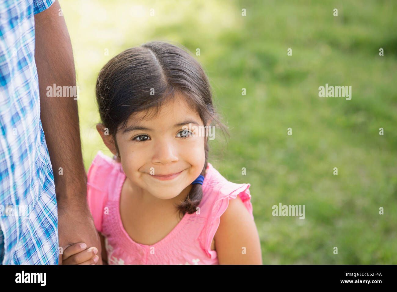 A young child in a pink dress holding her father's hand. Stock Photo
