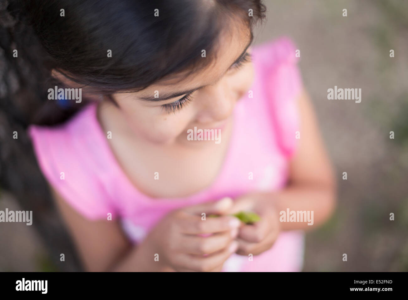 View from above of a child, a girl with dark brown hair and brown eyes. Stock Photo