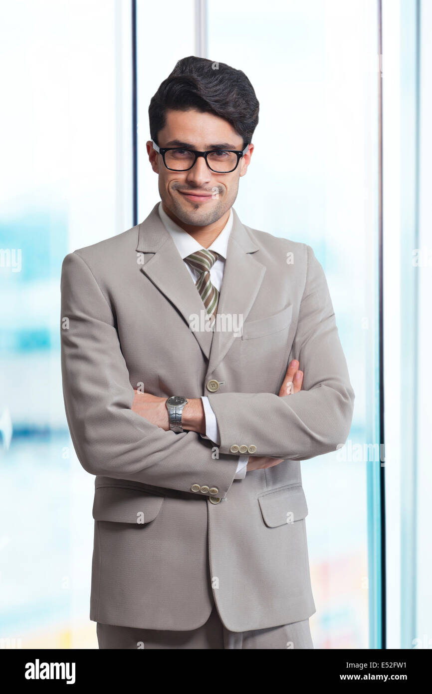Portrait of smiling businessman standing arms crossed in office Stock ...