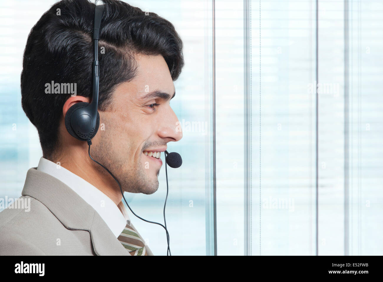 Side view of male customer service representative wearing headset in ...