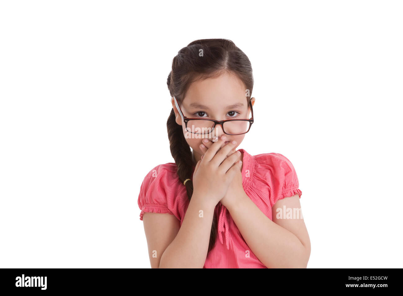 Portrait of little girl covering mouth with hands Stock Photo