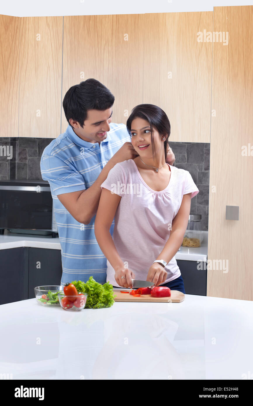 Man Putting Necklace On Woman In Kitchen Stock Photo Alamy