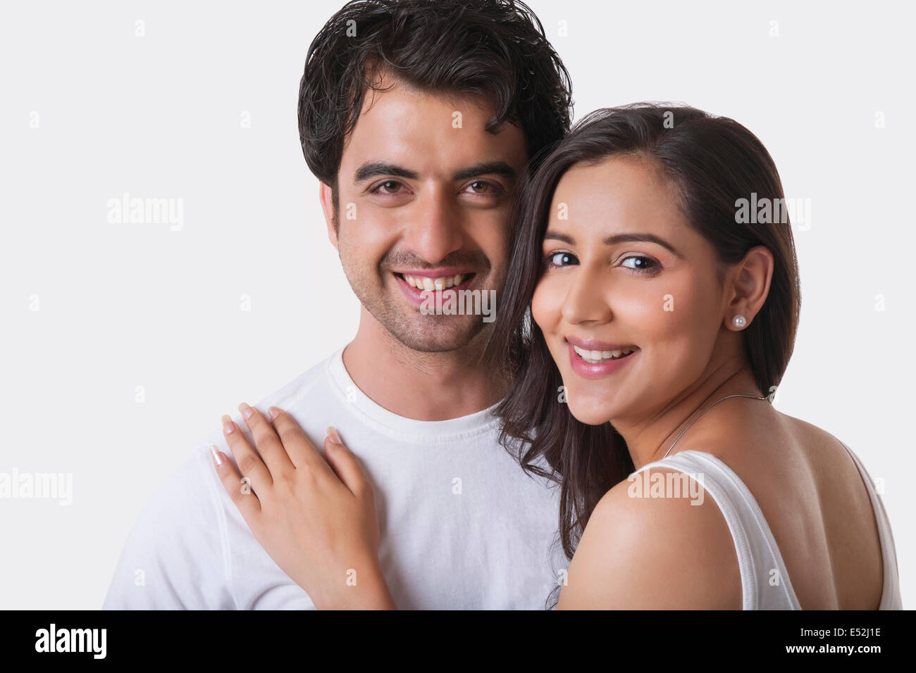 Portrait of young couple smiling against white background Stock Photo ...
