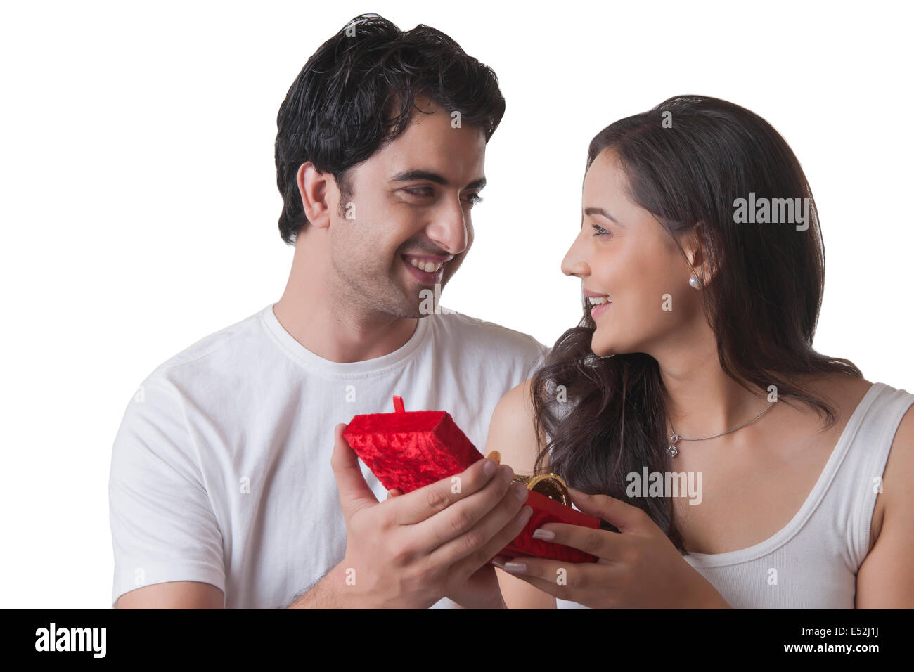 Handsome man gifting bangles to woman against white background Stock