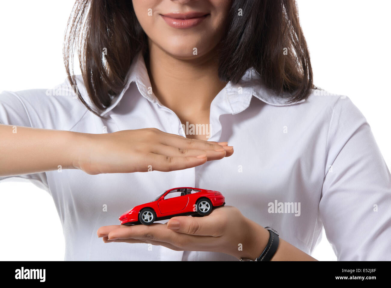 Midsection of female insurance agent holding toy car against white background Stock Photo