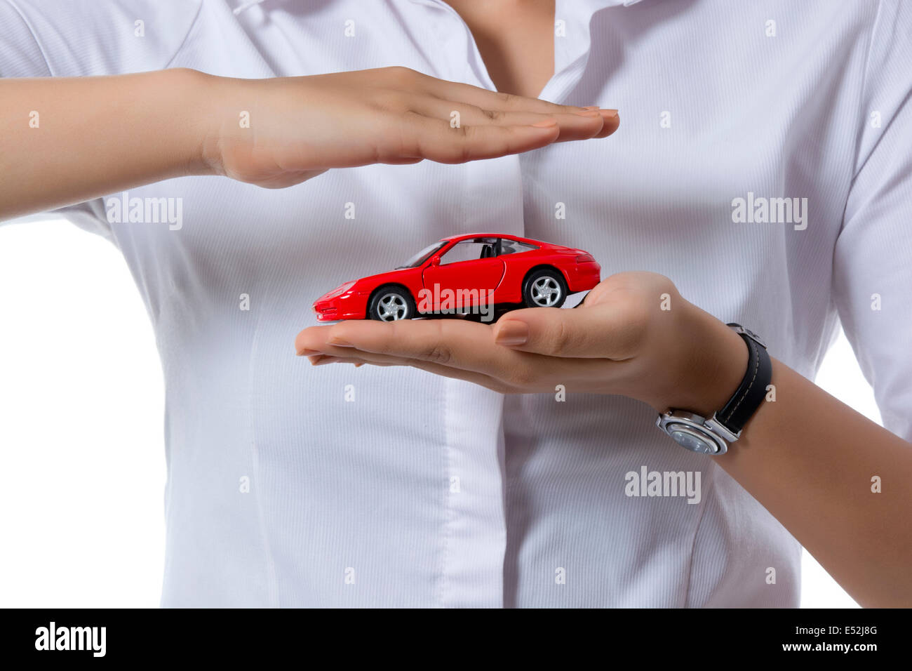 Midsection of insurance agent covering toy car against white background Stock Photo