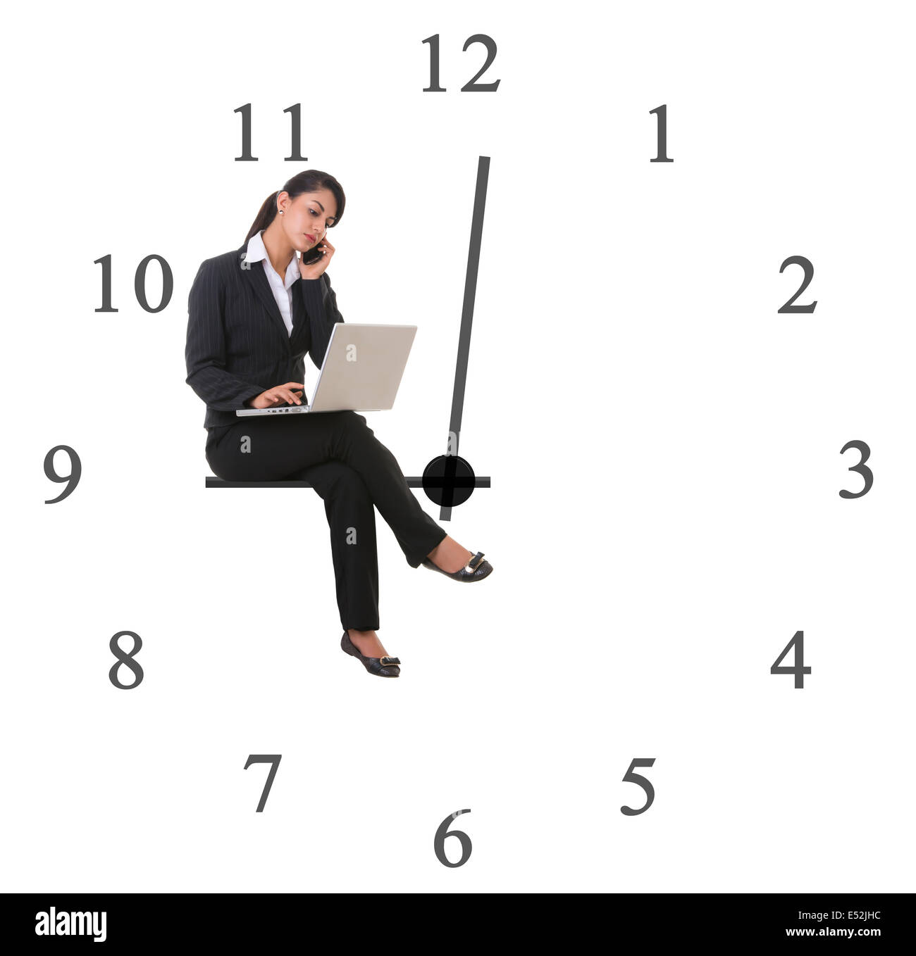 Businesswoman using laptop while sitting on clock hand representing late working against white background Stock Photo