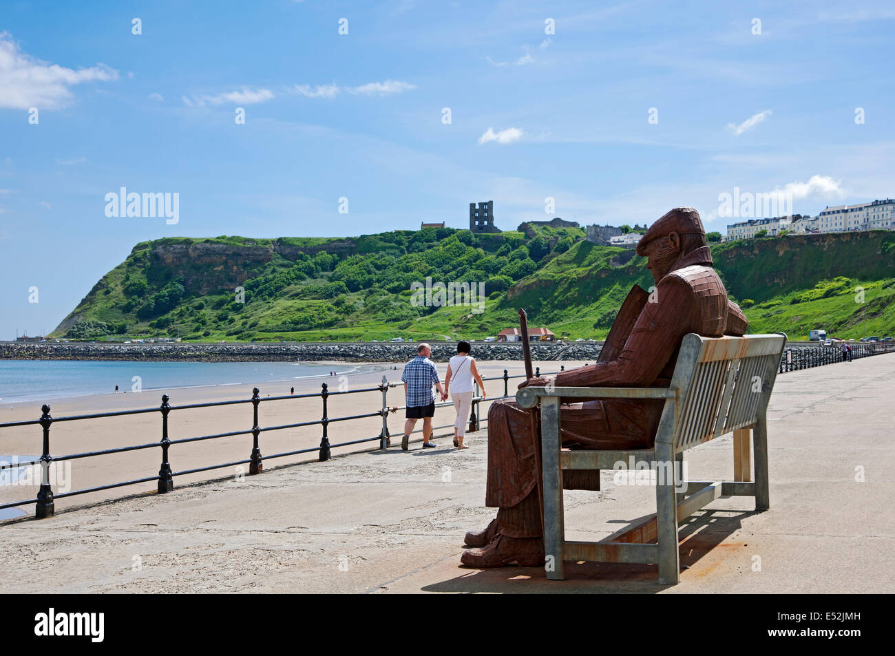 People tourists and large steel sculpture of former miner in summer North Bay Scarborough North Yorkshire England UK United Kingdom GB Great Britain Stock Photo