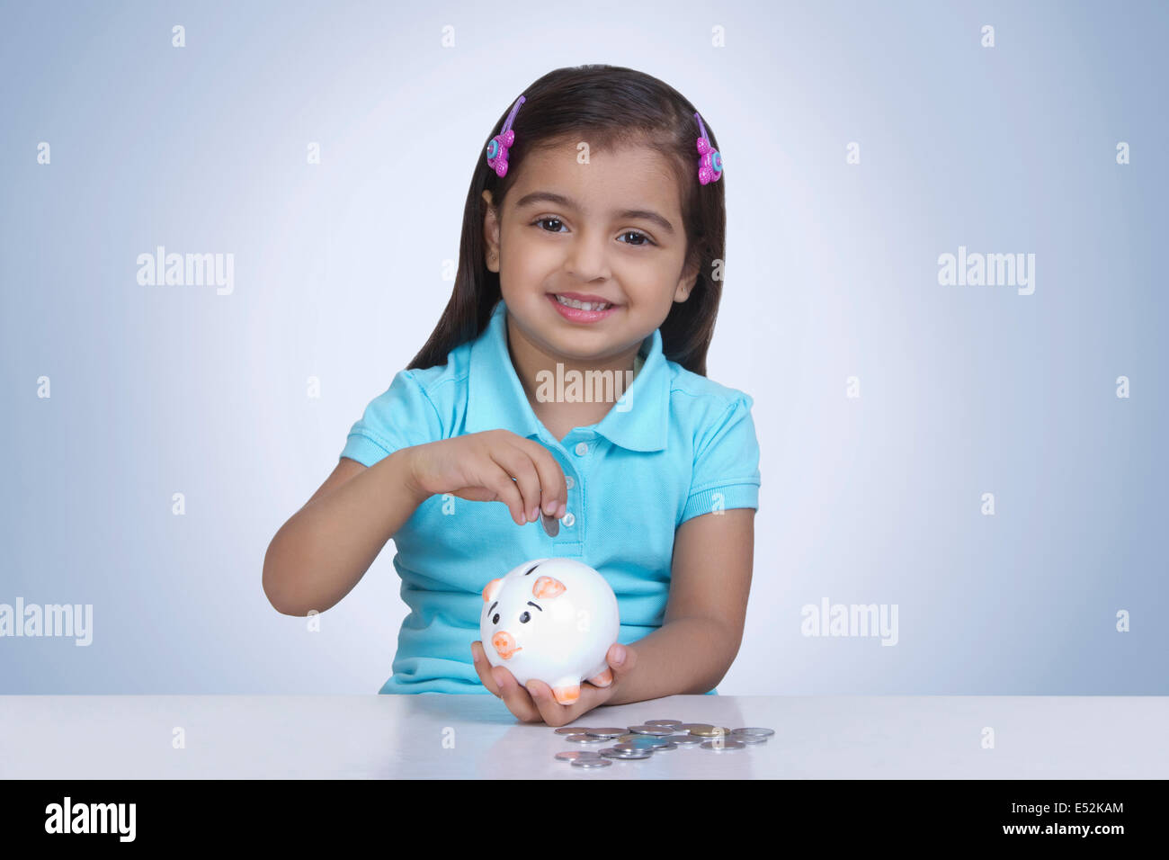 Indian girl holding piggy bank hi-res stock photography and images - Alamy