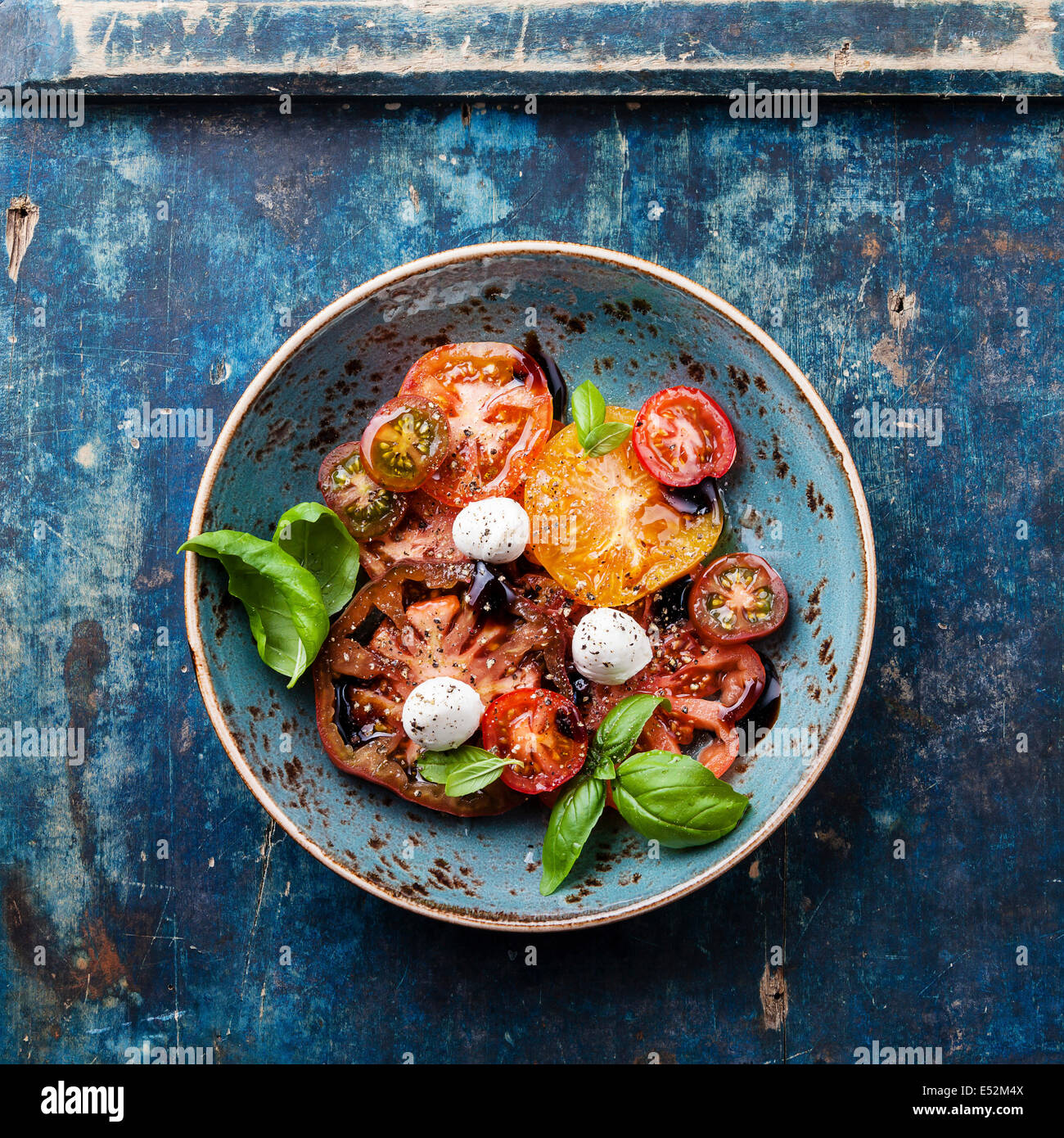 Ripe fresh colorful tomatoes salad with olive oil and balsamic vinegar