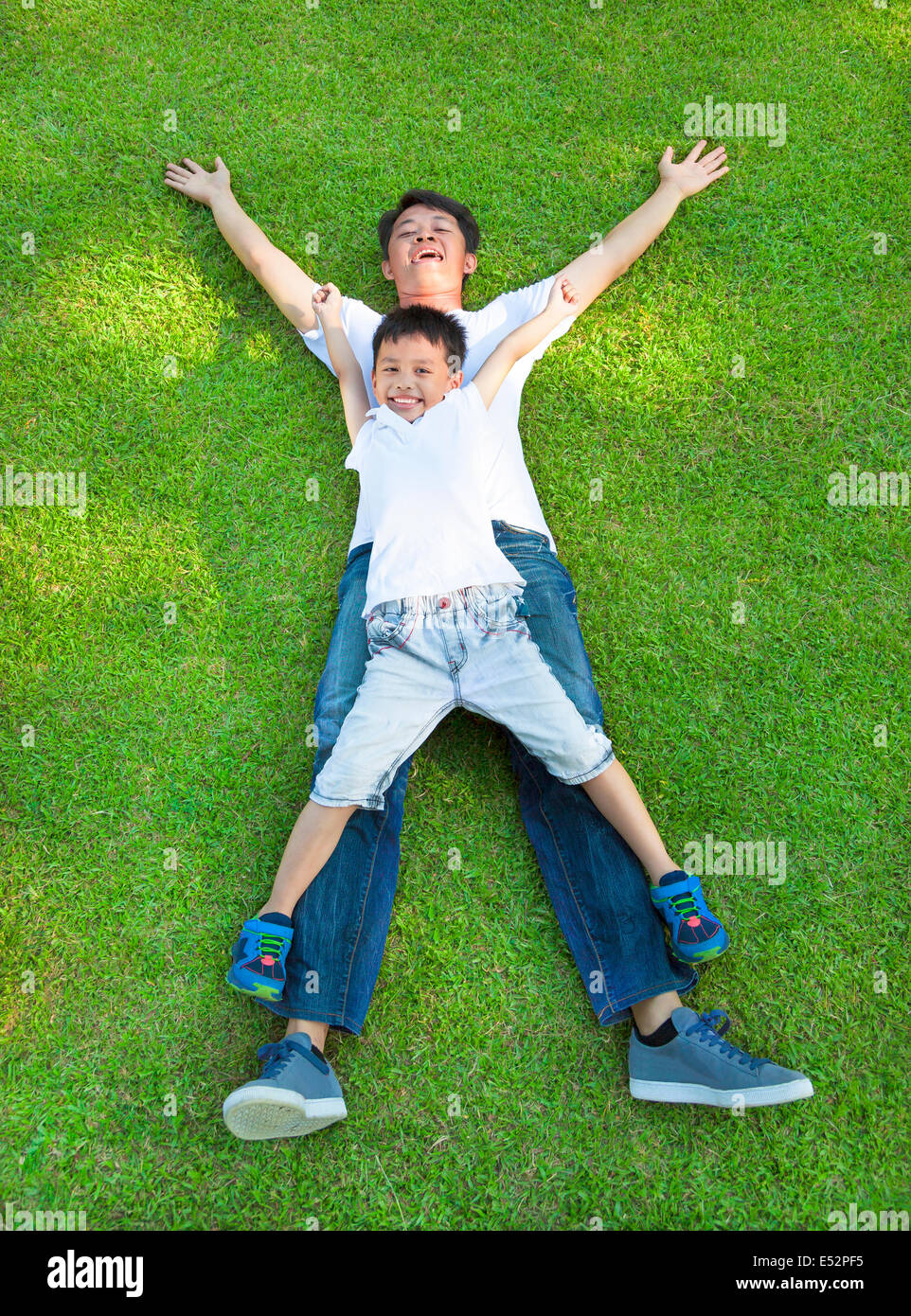 happy father and son lying on a meadow together Stock Photo