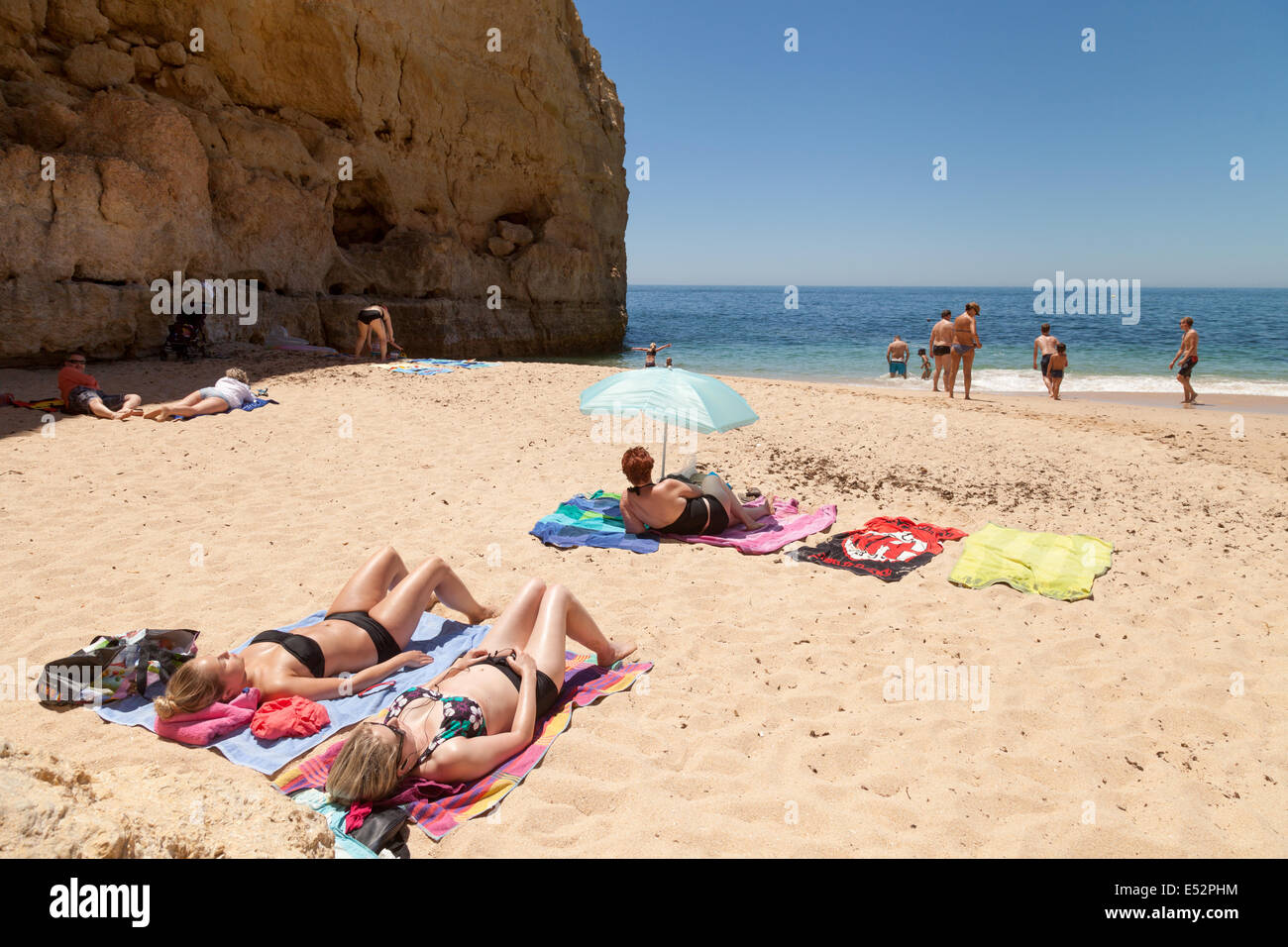 People sunbathing on summer holiday on Vale Centeanes beach, Algarve