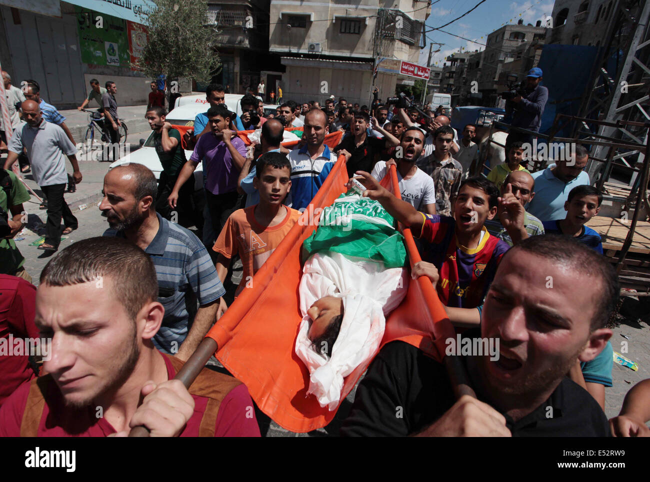 Gaza City, Gaza Strip, Palestinian Territory. 18th July, 2014. Mourners carry the body of one of three Palestinian teenage siblings from Abu Musalam family, who medics said were shelled by an Israeli tank inside their house, during their funeral in Beit Lahiya in the northern Gaza Strip July 18, 2014 . Israel stepped up its land offensive in Gaza with artillery, tanks and gunboats on Friday and declared it could ''significantly widen'' an operation Palestinian officials said was killing ever greater numbers of civilians. Credit:  ZUMA Press, Inc./Alamy Live News Stock Photo