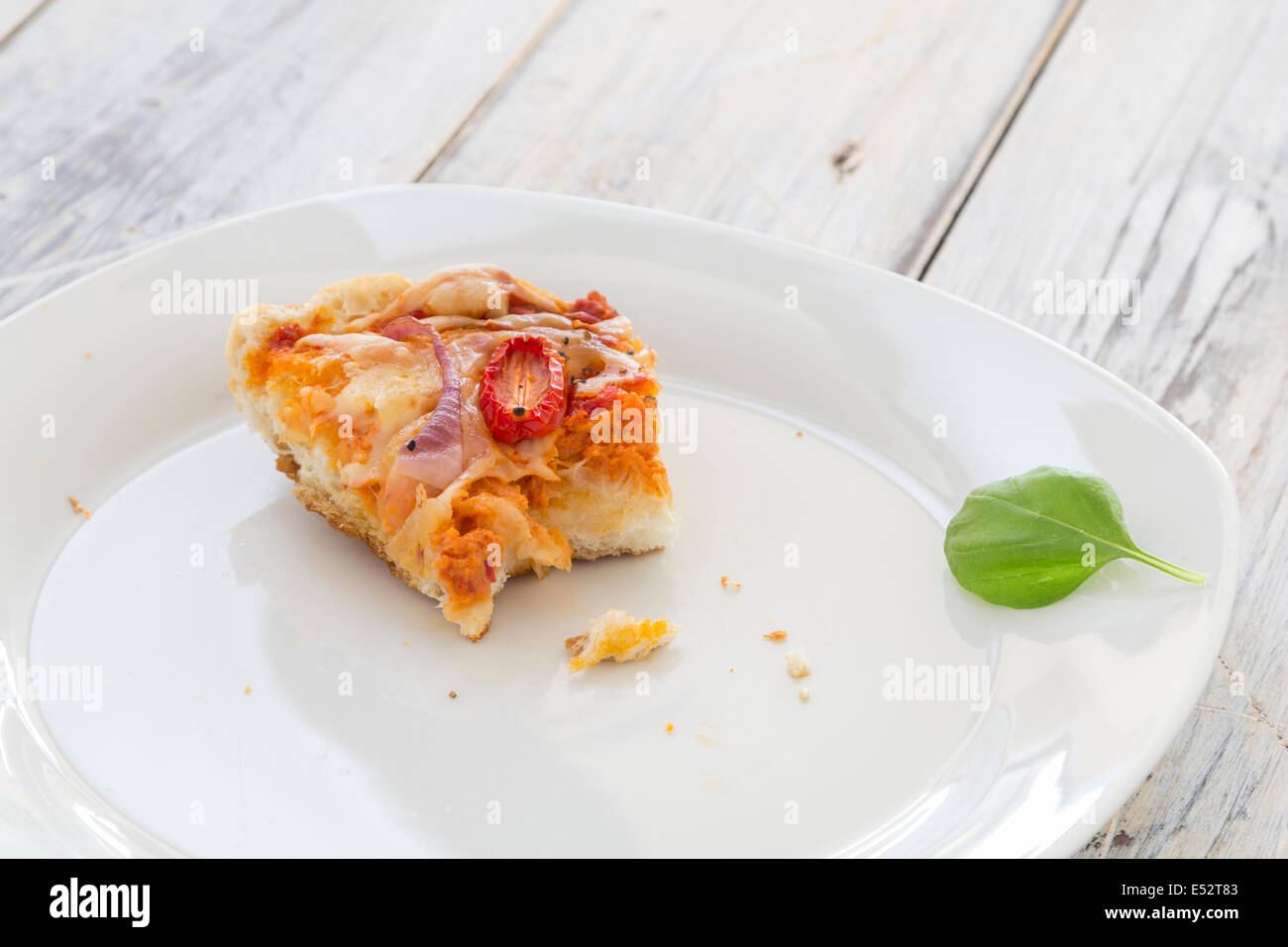 leftover pizza from the previous day on a plate on a rustic wooden