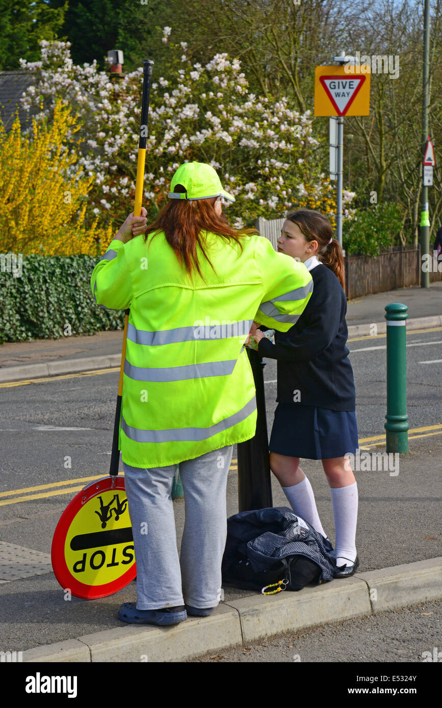 School pedestrian crossing monitor (lollipop woman), St.Jude's Road, Englefield Green, Surrey, England, United Kingdom Stock Photo