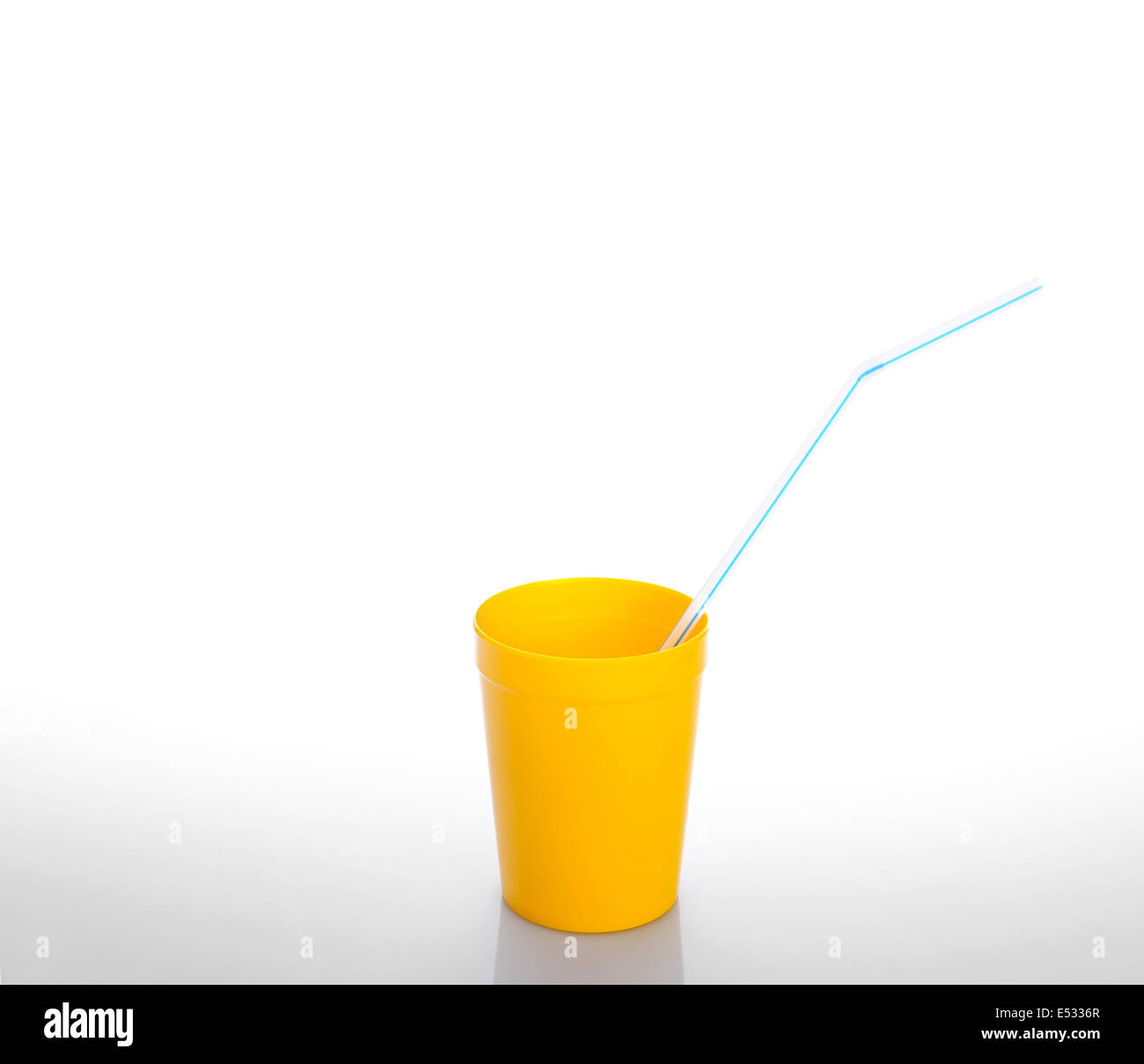 Yellow cup with blue drinking straw isolated over white Stock Photo