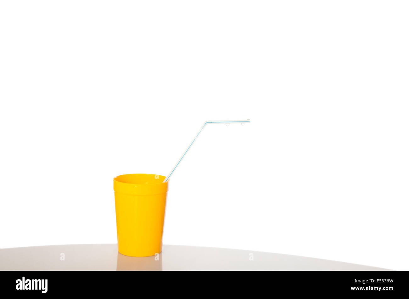 Yellow cup with blue drinking straw isolated over white Stock Photo