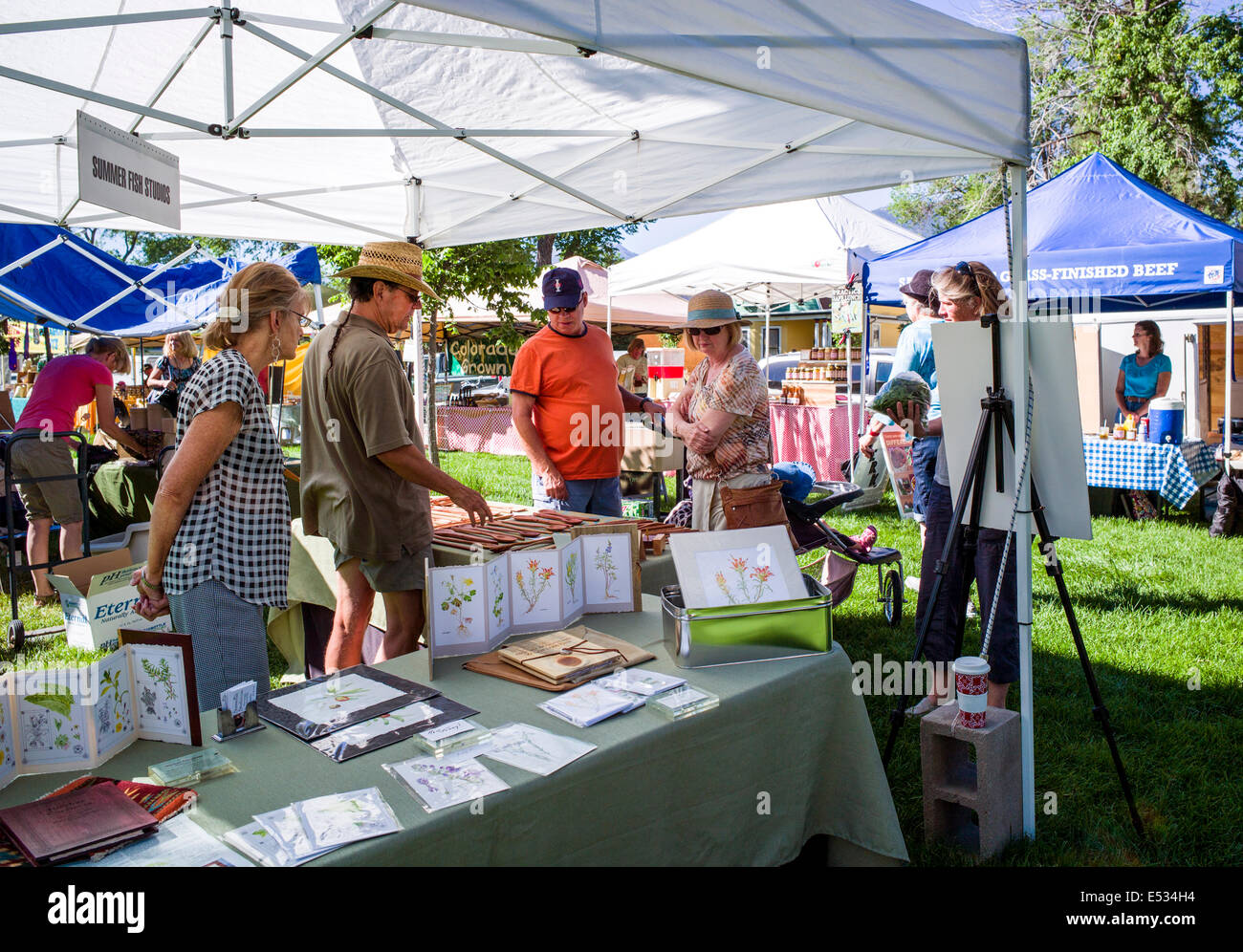 Vendors sell fresh vegetables, produce and other items at a seasonal farmers market in small mountain town of Salida, Colorado Stock Photo
