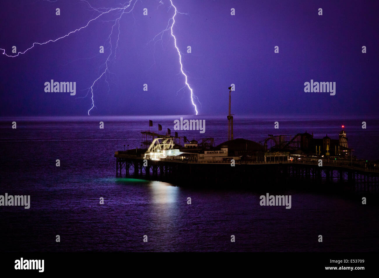 Brighton, UK. 19 July 2014. Lightning strikes over the Brighton Pier during a summer lightning storm. Stormy weather is predicted for most of the weekend. Credit:  PhotoMadly/Alamy Live News Stock Photo