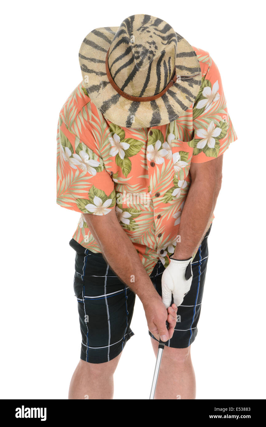Closeup of an eclecticly dressed male tourist standing over a golf ball preparing to take his turn. Wearing a Hawaiian Shirt Stock Photo