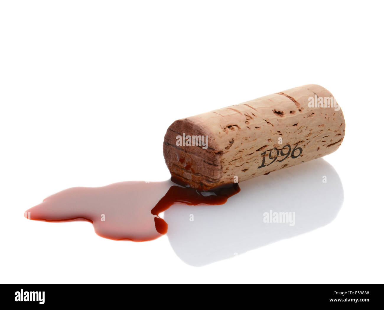 Closeup of a wine cork and a wine spill on white with reflection. Horizontal format. Stock Photo