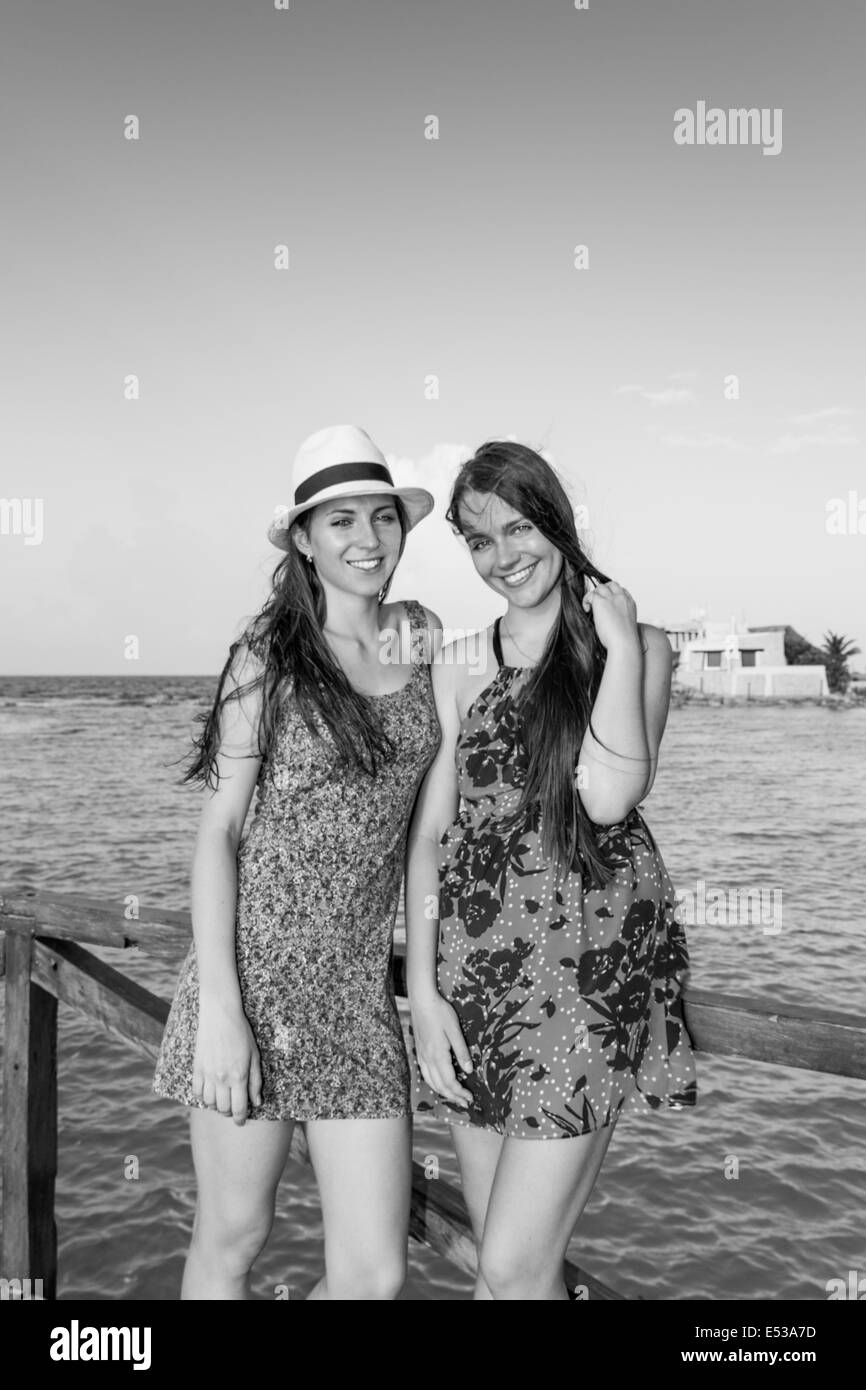 Two young women on vacation by the beach Stock Photo