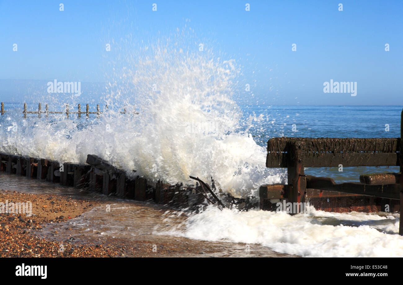 Waves breaking against old sea defences at Cart Gap, near Happisburgh, Norfolk, England, United Kingdom. Stock Photo