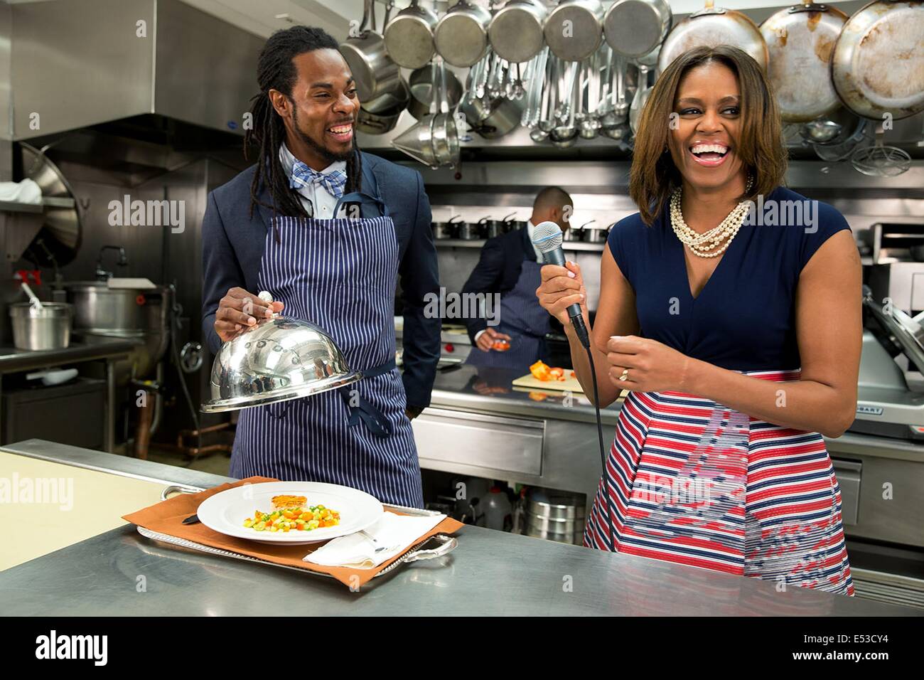 US First Lady Michelle Obama participates in a 'Let's Move!' taping with Richard Sherman of the Seattle Seahawks in the White House Kitchen May 21, 2014 in Washington, DC. Let's Move is an initiative by the First Lady to improve how children eat and exercise. Stock Photo