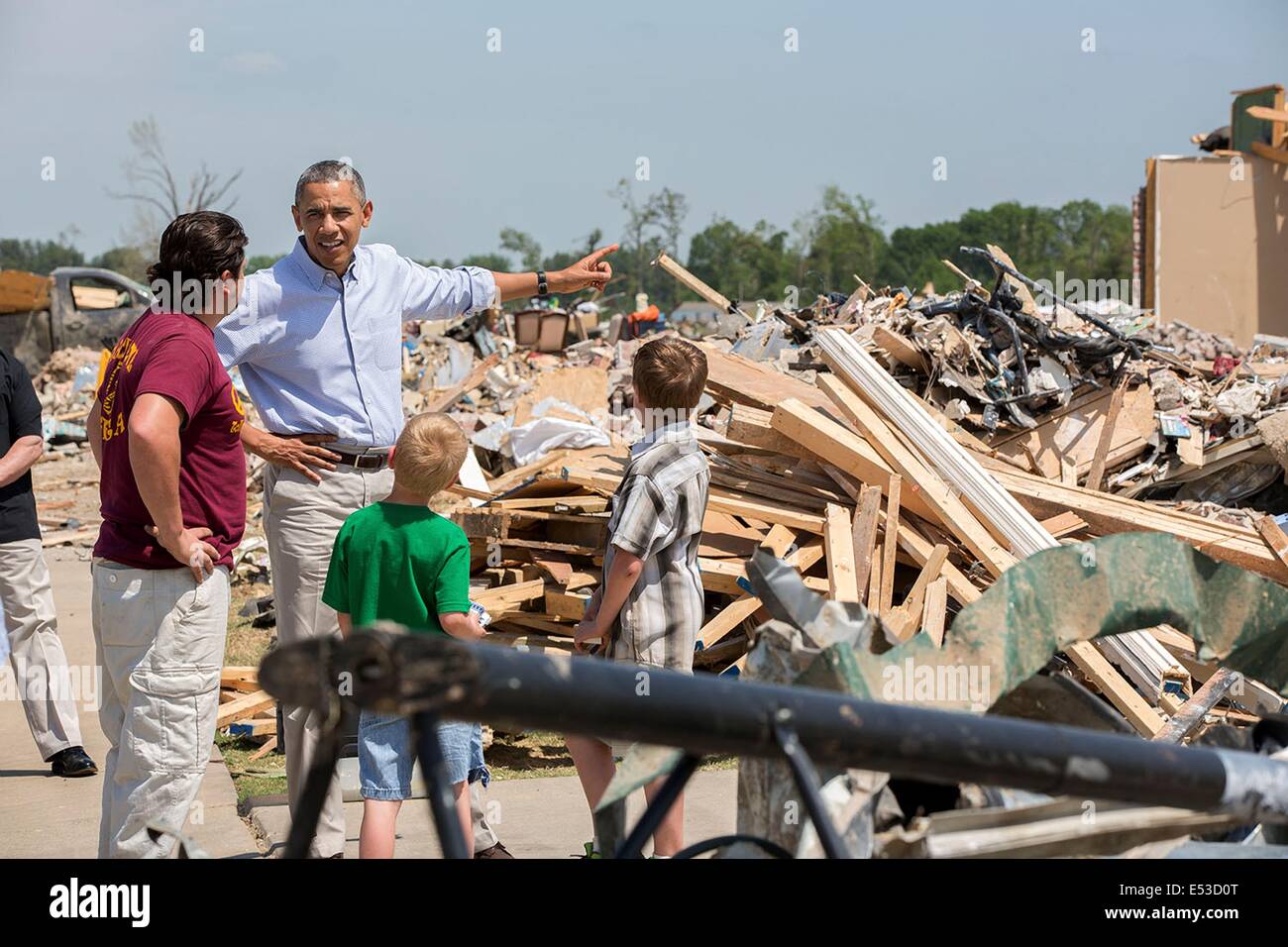 US President Barack Obama talks with Daniel Smith and his sons Garrison Dority and Gabriel Dorit as he tours the wreckage of a tornado-damaged neighborhood May 7, 2014 in Vilonia, Arkansas. Stock Photo