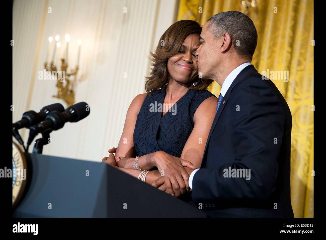 US President Barack Obama kisses First Lady Michelle Obama following her remarks at an Affordable Care Act reception in the East Room of the White House May 1, 2014 in Washington, DC. Stock Photo