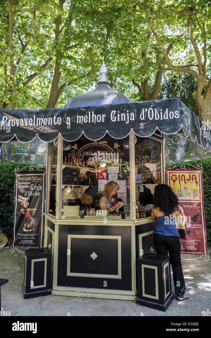Young lady dispensing the famous Obidos cherry liqueur called Ginja in chocolate cups at a festival in Caldas da Rainha Portugal Stock Photo