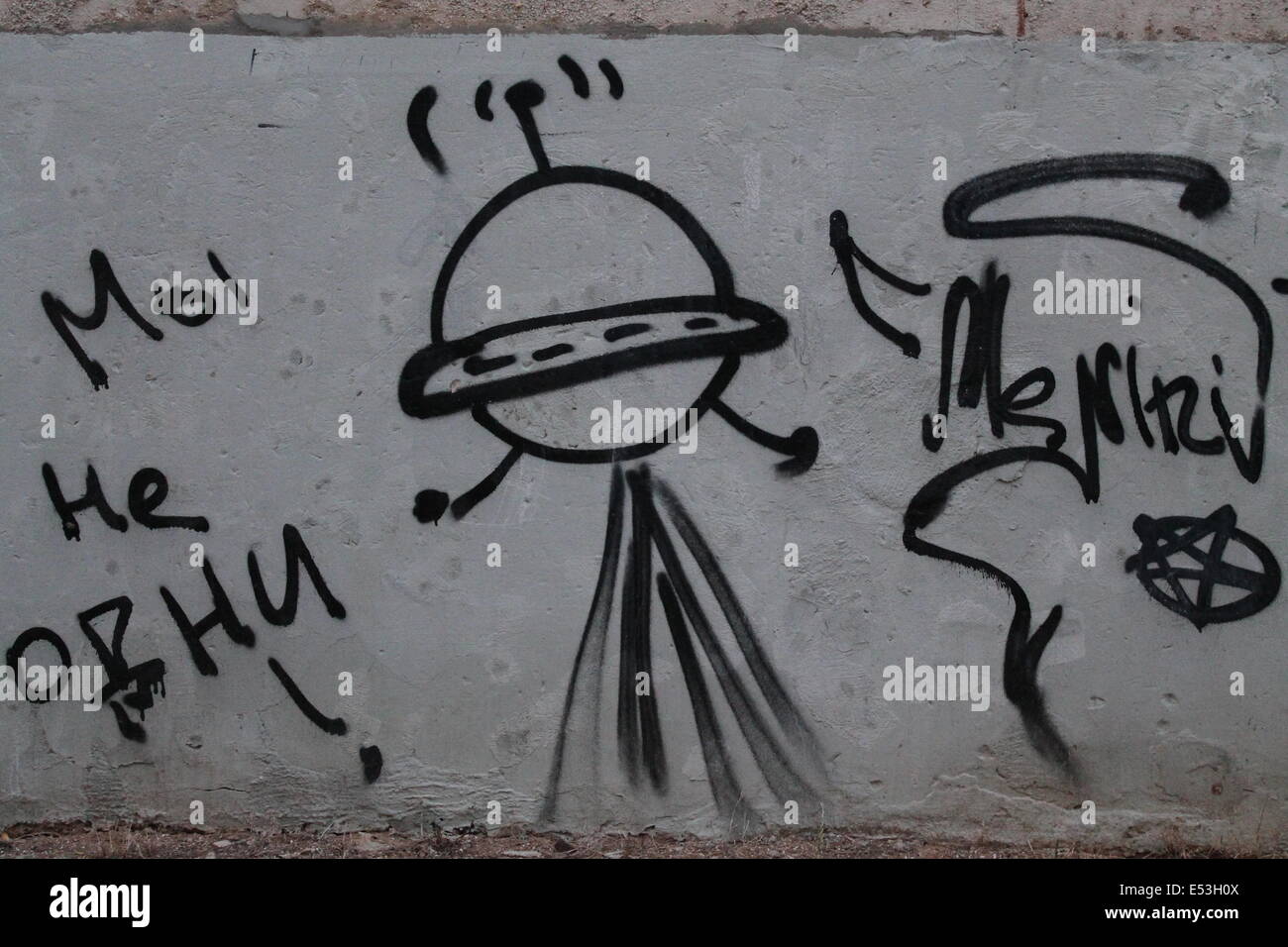street art on the wall flying UFO with words Stock Photo - Alamy