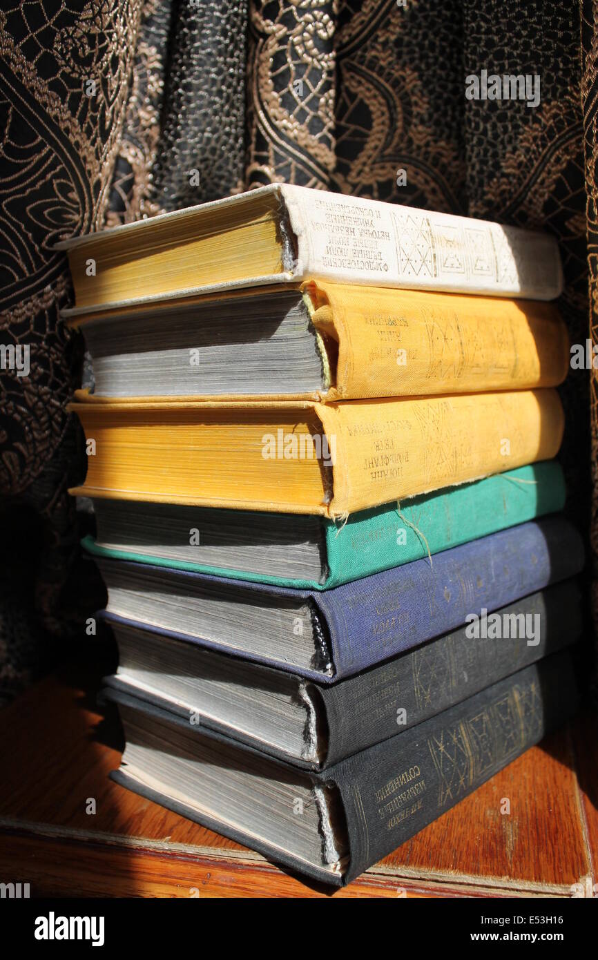 nice old books with fabric covers with golden stamping on titles lay in