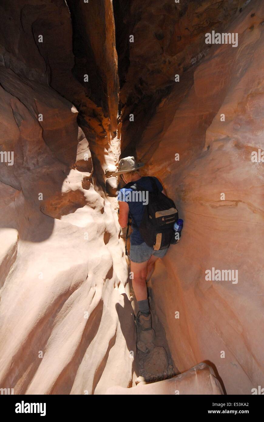 Senior citizen climbing through slot canyon. Stock Photo