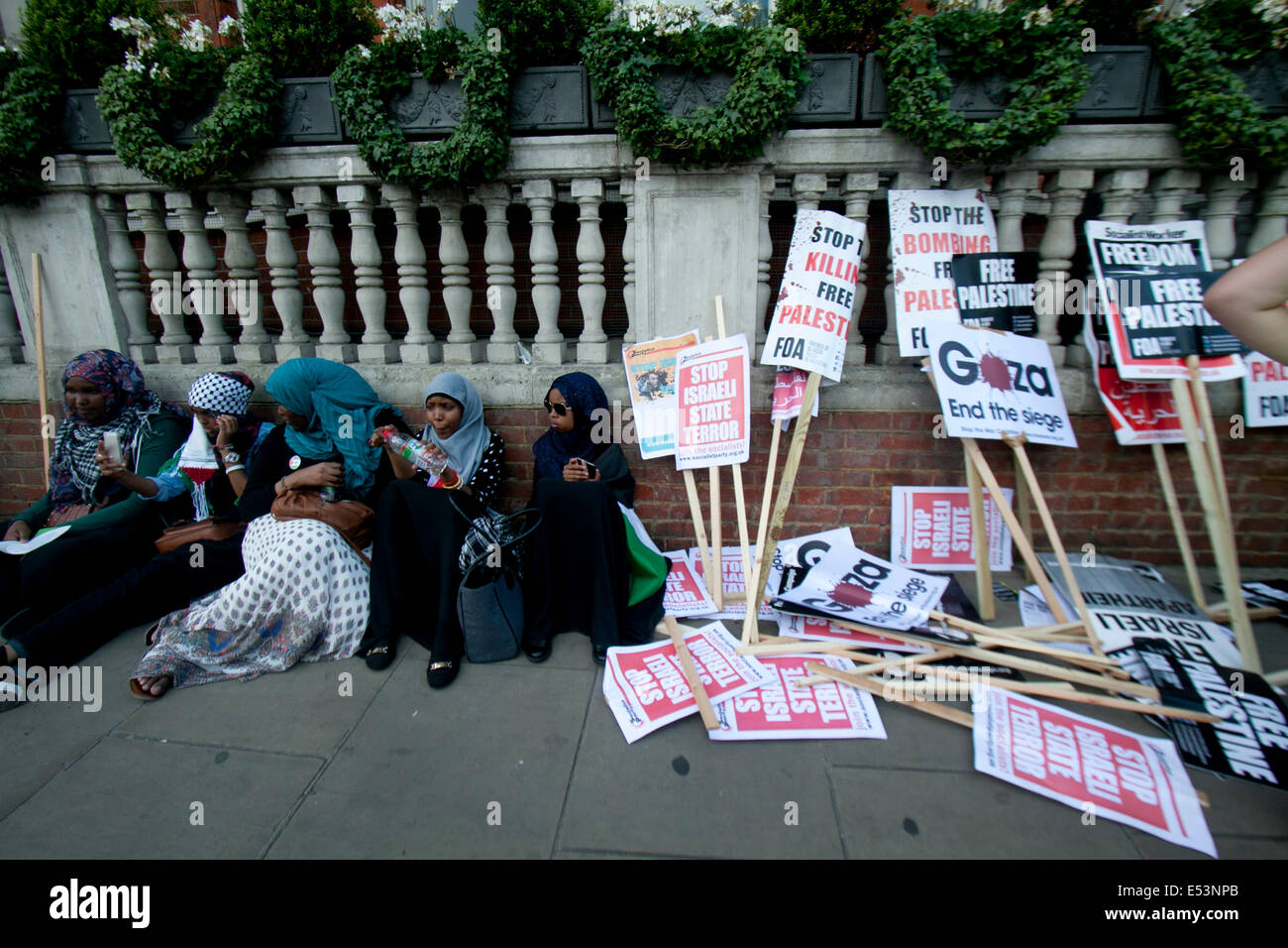 London UK. 19th July 2014. Protesters sit next to placards  as thousands took part in a protest outside the Israel embassy in London to show support for the Palestinian people and against Israeli military strikes in Gaza Credit:  amer ghazzal/Alamy Live News Stock Photo