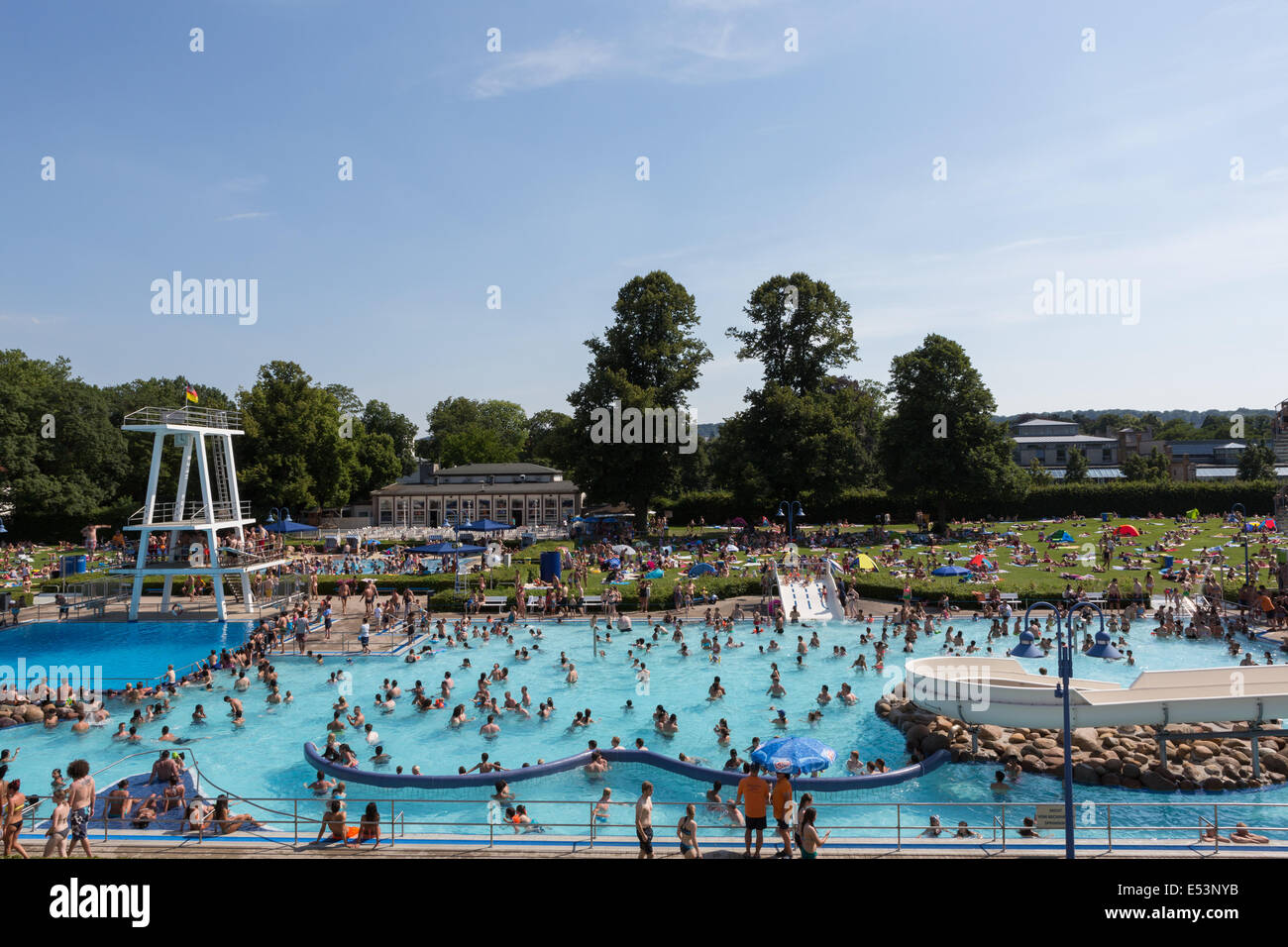 Crowded outdoor swimming pool full of people bathing in Germany, on a