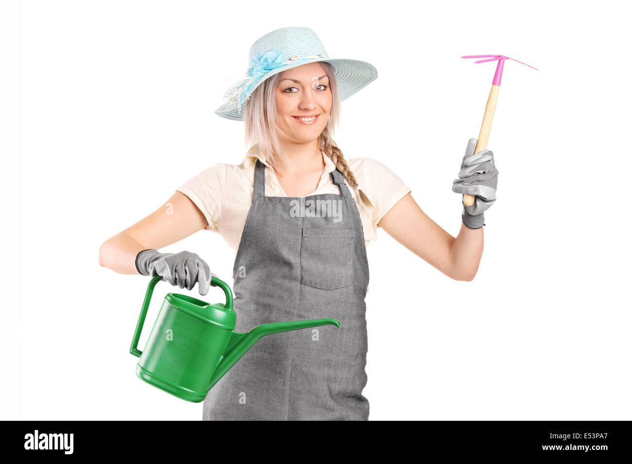 Female gardener holding mattock and watering can Stock Photo