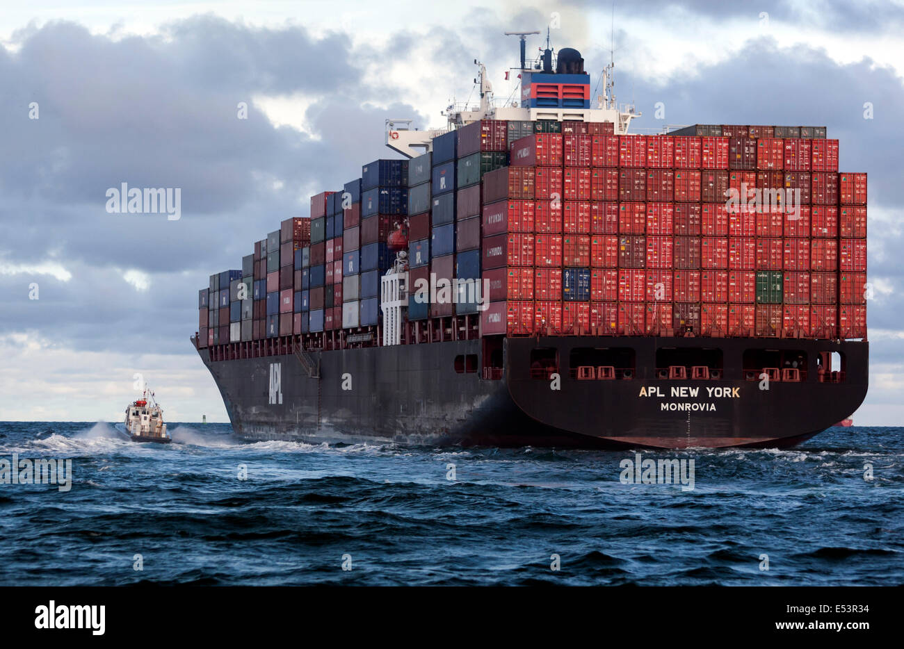 APL New York Monrovia, Container ship before crossing the Panama canal in the Gulf of Panama with a tugboat Stock Photo