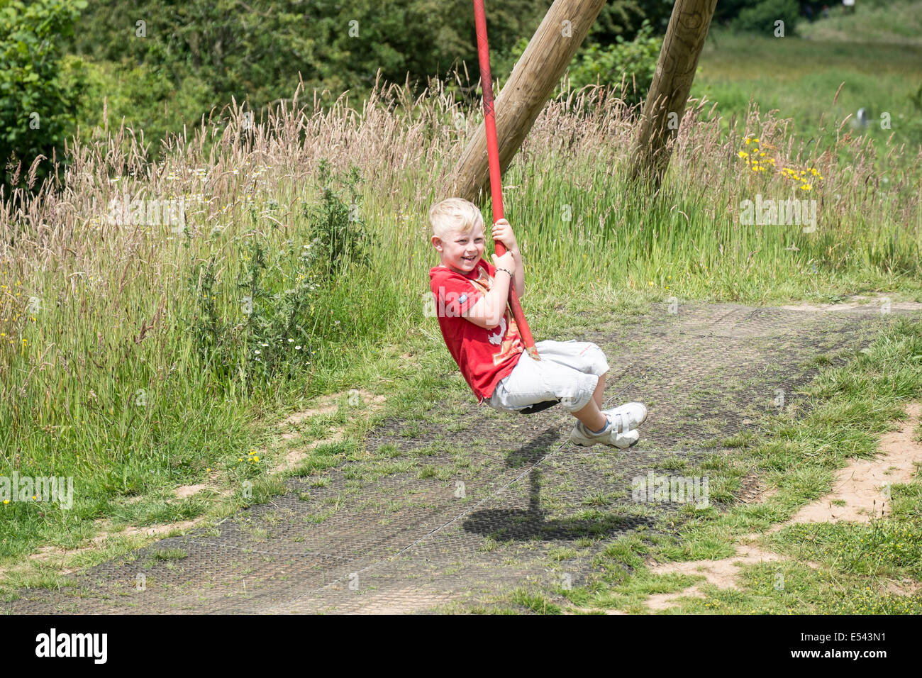 Boy using zip wire ride on adventure playground Stock Photo