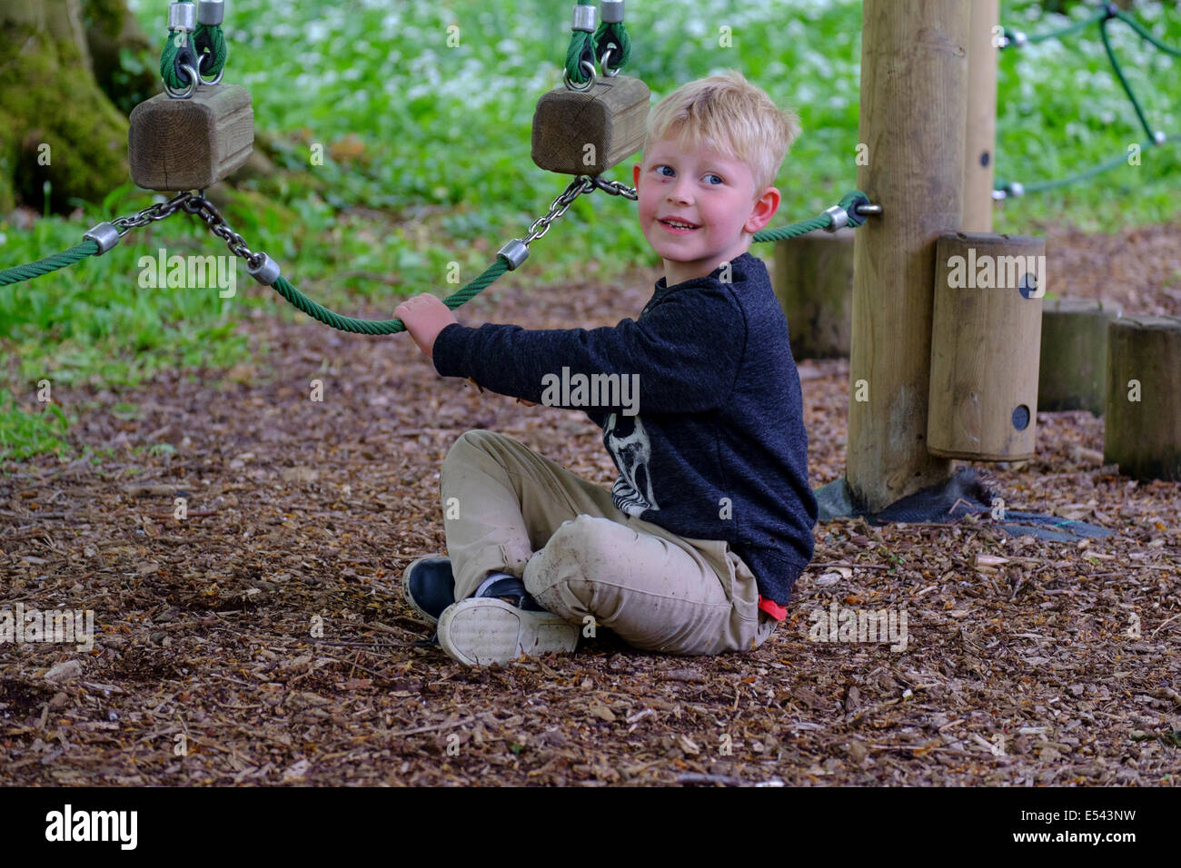 Blonde boy playing on adventure playground Stock Photo