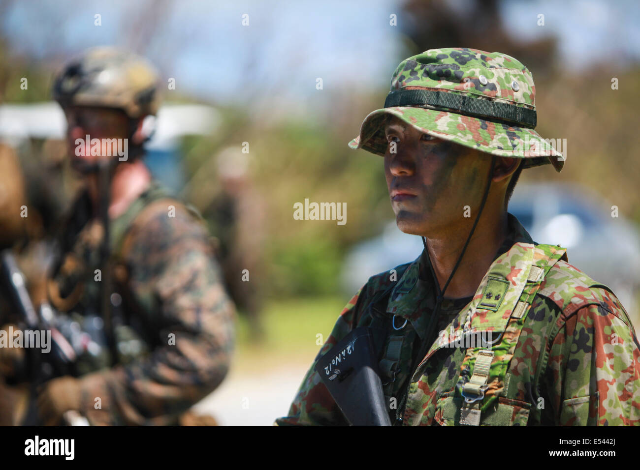 Japanese Ground Self-Defense and US Marine scout swimmer special operation soldiers perform a beach landing while practicing small unit level techniques as part of the Japan Observer Exchange Program at Kin Blue beach July 16, 2014 in Okinawa, Japan. Stock Photo