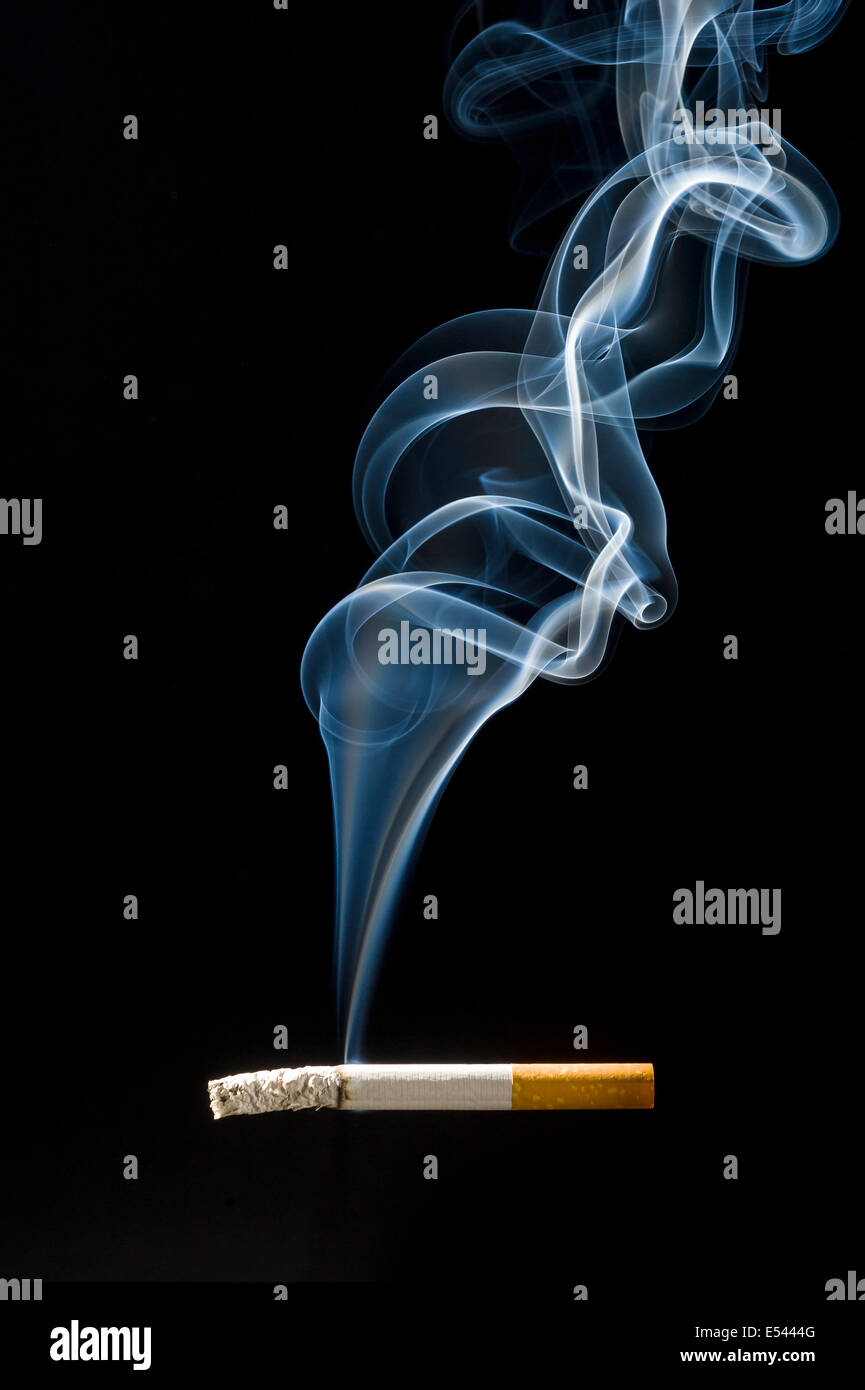 Rising smoke from filter tipped cigarette hires stock photography and