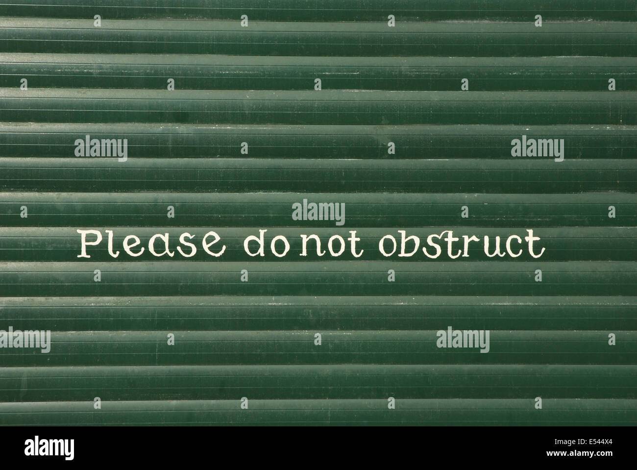 Sign - Please do not obstruct - painted on garage door Stock Photo