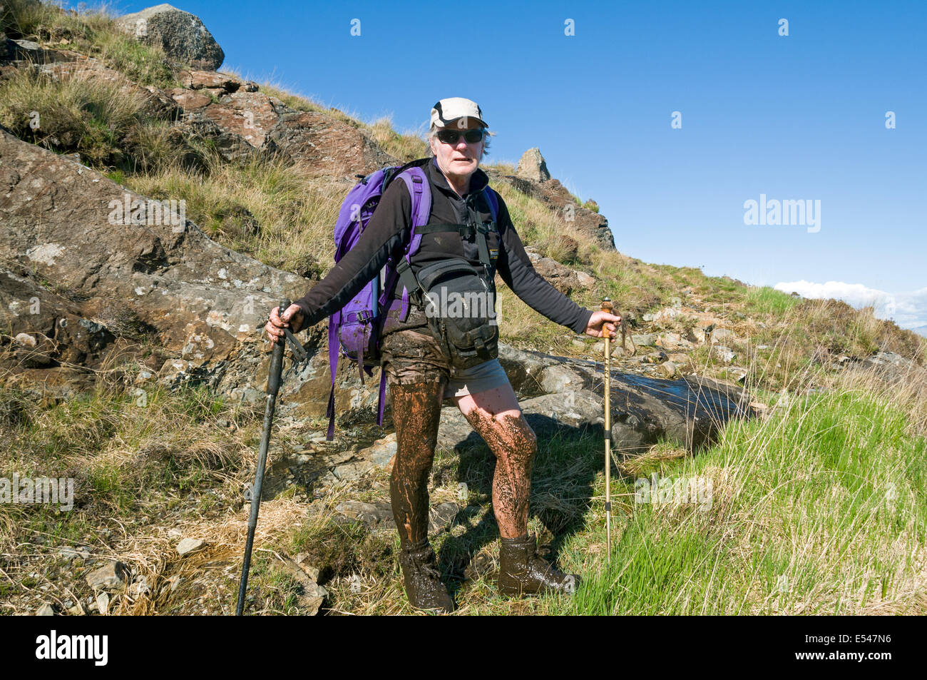 A mud covered walker after sinking in deep mud on the Dibidil to Kinloch coastal path, Isle of Rum, Scotland, UK Stock Photo