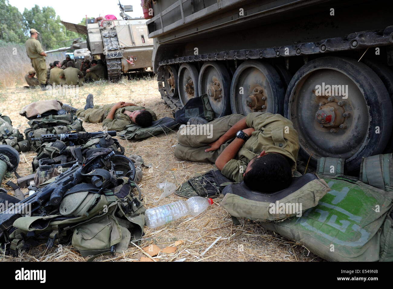 Unspecified, Israel. 19th July, 2014.  Israeli soldiers sleep next to an APC in an army deployment area near Israel's border with the Gaza Strip, on July 19, 2014, on the second day of Israeli ground invasion into Gaza Strip in order to destroy terror tunnels infrastructure. Credit:  Gili Yaari/NurPhoto/ZUMA Wire/Alamy Live News Stock Photo