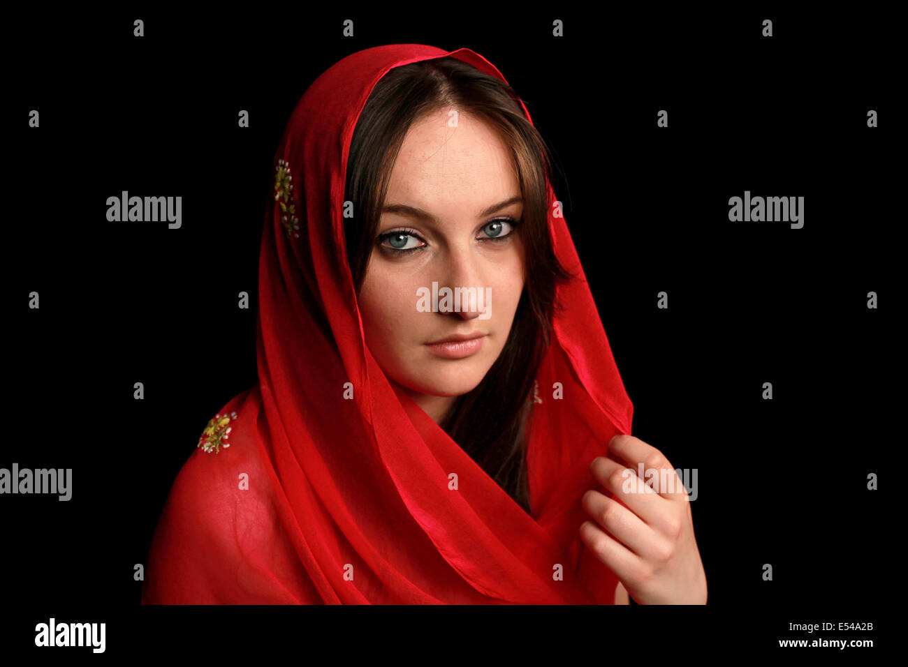 Arab girl with blue eyes wearing a red veil Stock Photo