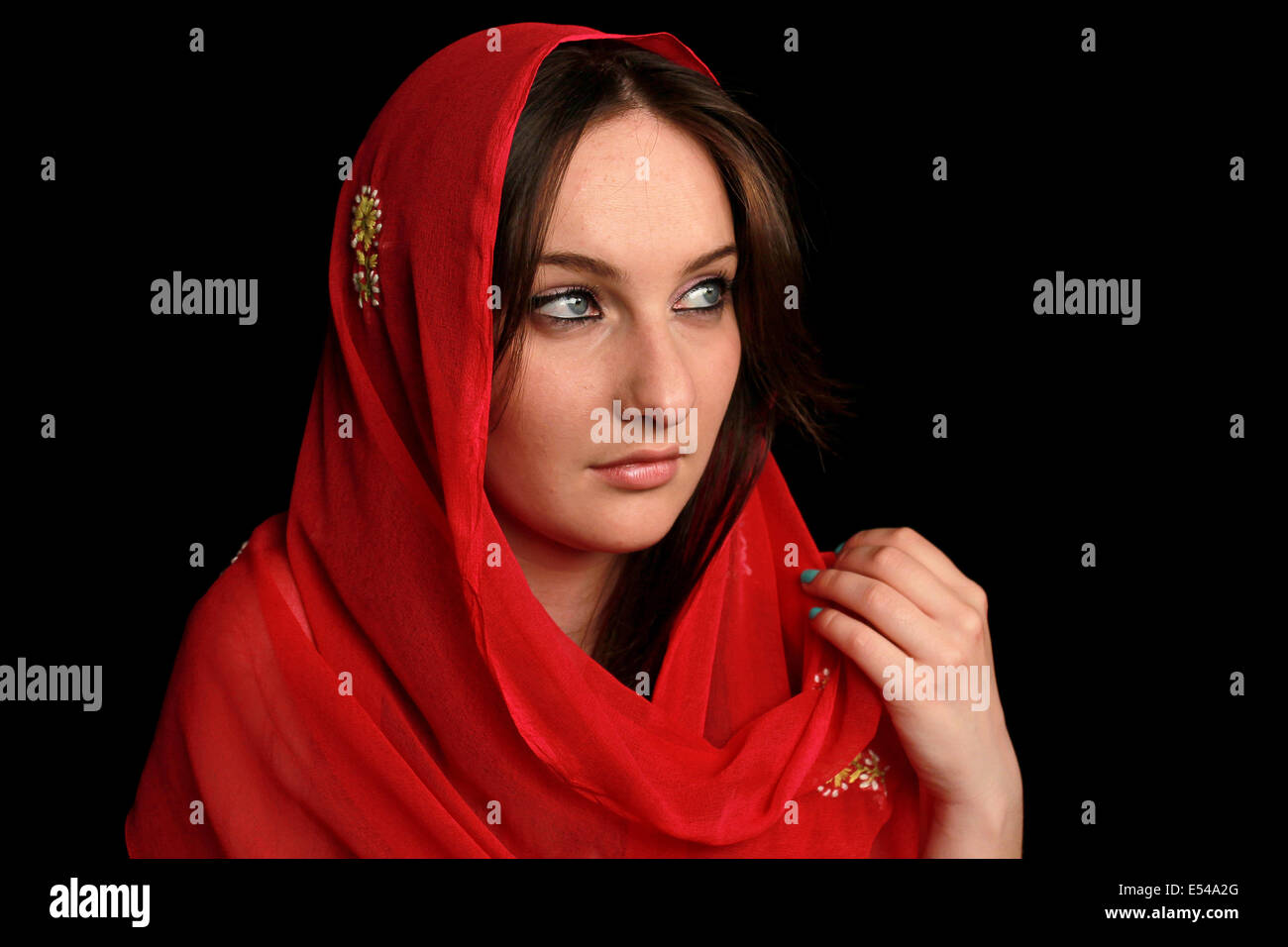 Arab girl with blue eyes wearing a red veil Stock Photo