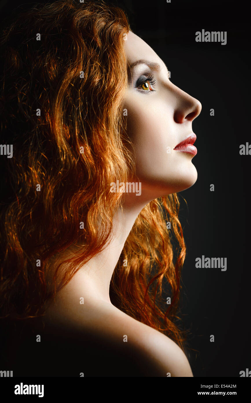 Closeup studio portrait of a beautiful redhead woman. Profile view Stock Photo